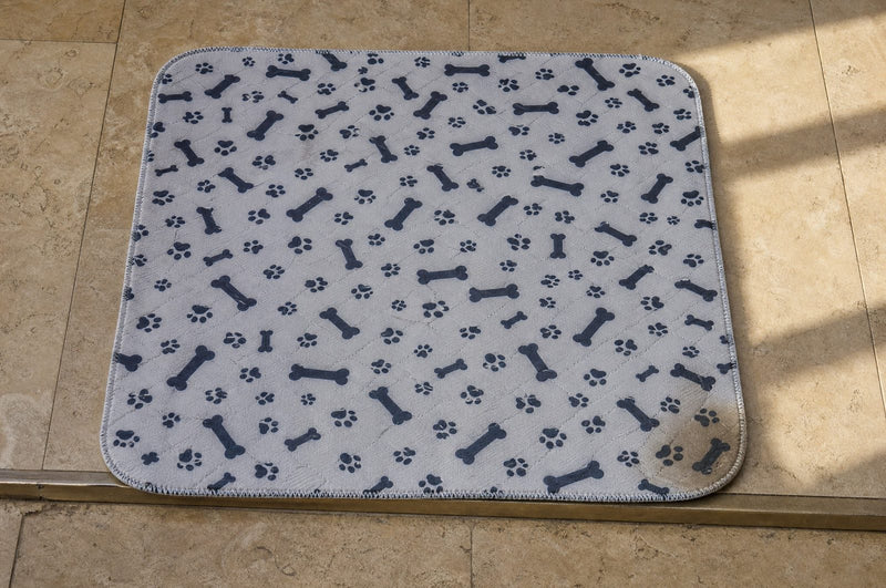 Looking straight down at a pee pad on a stone floor, a faint 