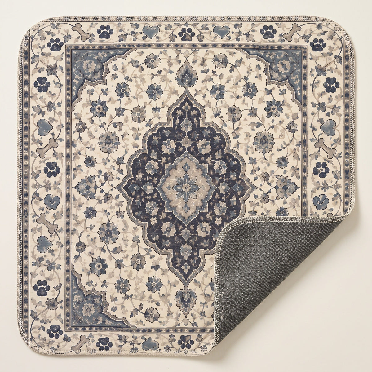 Ivory Paw Border washable pee pad, cream ground with a navy medallion and a paw and bone border, one corner turned