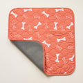 Orange Bones washable pee pad, one corner turned back to show the silicone-dot underside