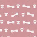 Blush pink print with white dog bones and paw prints over faint arches, used on the washable pee pad