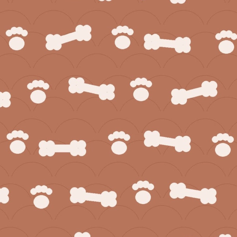 Clay brown print with cream dog bones and paw prints over faint arches, used on the washable pee pad